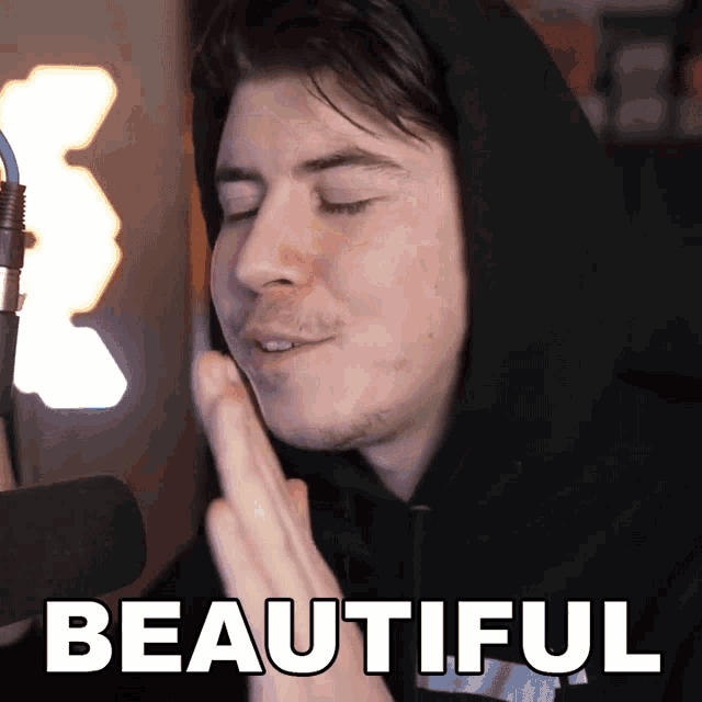 a man in a black hoodie says beautiful in white letters