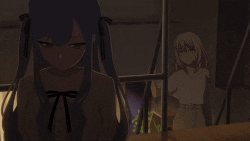 a girl with blue hair is looking down while another girl stands behind her