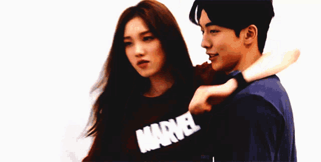 a man and a woman standing next to each other with the man wearing a shirt that says mad on it
