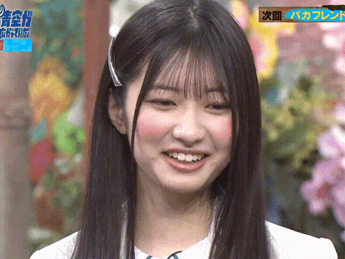 a close up of a woman 's face with flowers in the background and a sign that says ' a ' on it