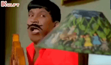 a man with a mustache is standing in front of a lamp and making a funny face .
