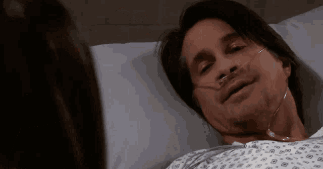 a man laying in a hospital bed with an oxygen mask on his face