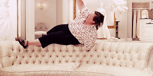 a woman is laying on a white couch with her legs up