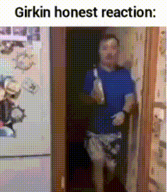 a man in a blue shirt is standing in a doorway holding a bottle of milk .