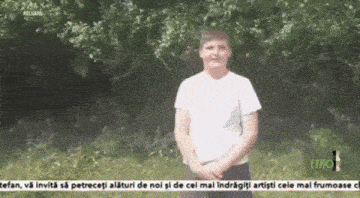 a boy in a white shirt is standing in front of trees with the word etho at the bottom of the screen
