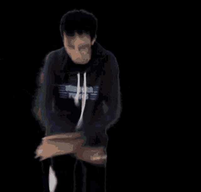 a blurry picture of a person wearing a sweatshirt that says ' extreme ' on it
