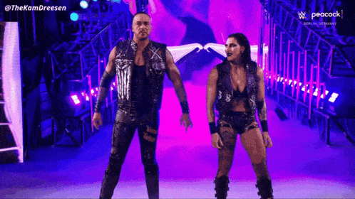 a man and a woman are standing next to each other in a purple tunnel .