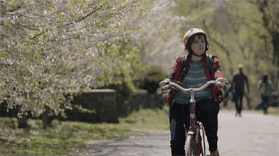a girl wearing a helmet is riding a bike down a path