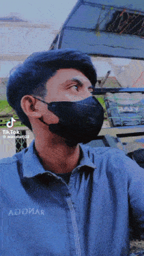 a man wearing a black mask has a tiktok icon on his face