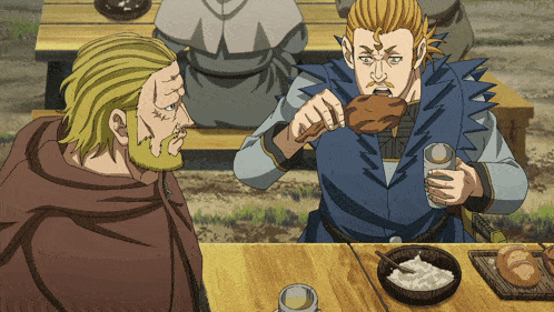 two men are sitting at a wooden table eating food