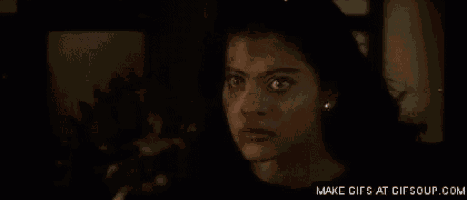 a close up of a woman giving a thumbs up in a dark room .