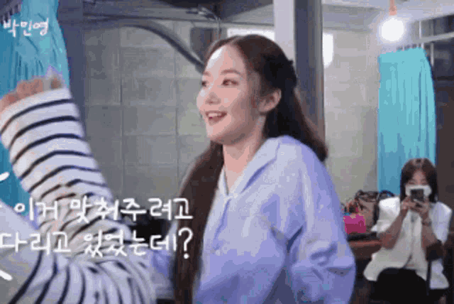 a woman in a striped shirt is talking to another woman in a blue shirt