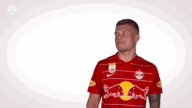 a man is wearing a red shirt with a bull on it