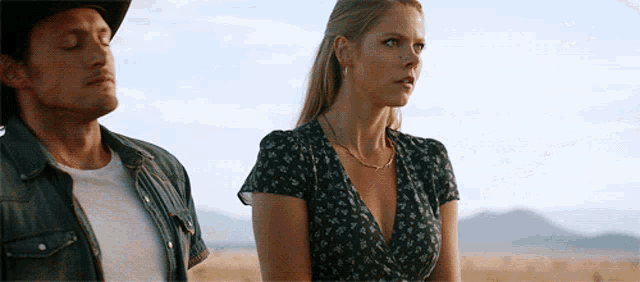 a man and a woman are standing in a field