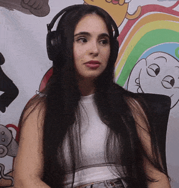 a woman wearing headphones is sitting in front of a rainbow