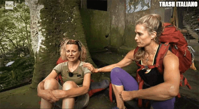 a woman with a backpack sits next to another woman who is crying and says trash italiano on the bottom