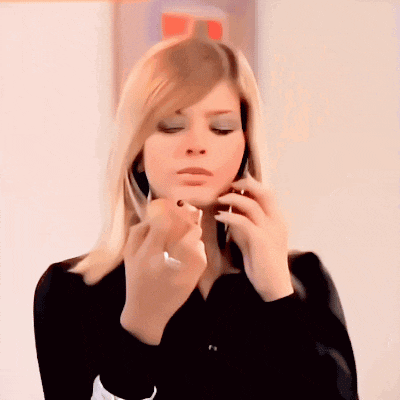 a woman in a black shirt is applying lipstick to her lips