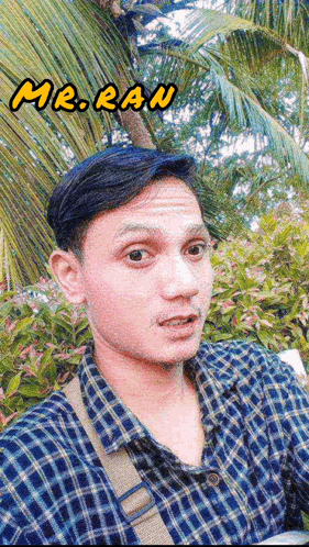a man in a plaid shirt takes a selfie with the name mr. ran below him