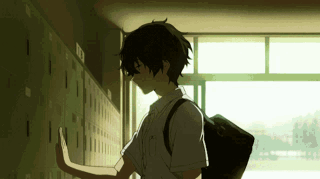 a boy stands in front of a row of lockers with the number 13 on the wall