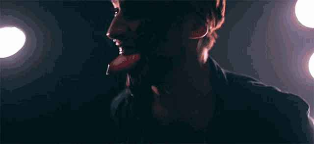 a close up of a man 's face with his tongue out