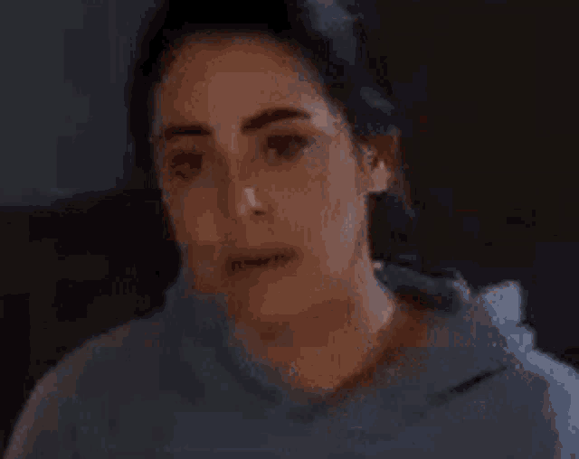 a woman is sitting down with her eyes closed and the word what is on her face .