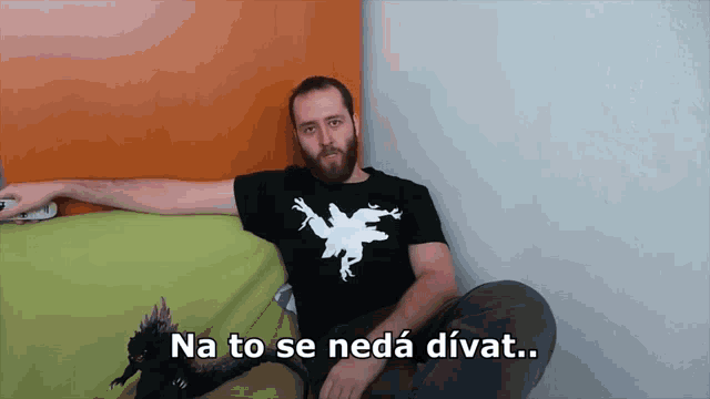 a man with a beard is sitting on a couch with the words na to se neda divat