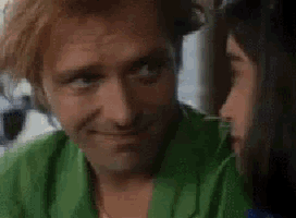 a man in a green shirt is talking to a woman .