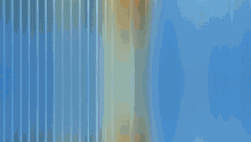 a window with vertical blinds and a blue curtain behind it