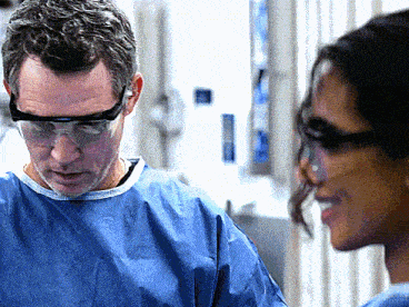 a man wearing goggles talks to a woman wearing glasses
