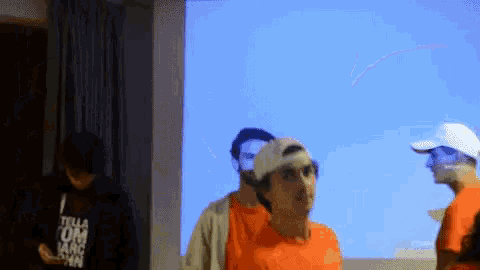 a man wearing an orange shirt that says tesla