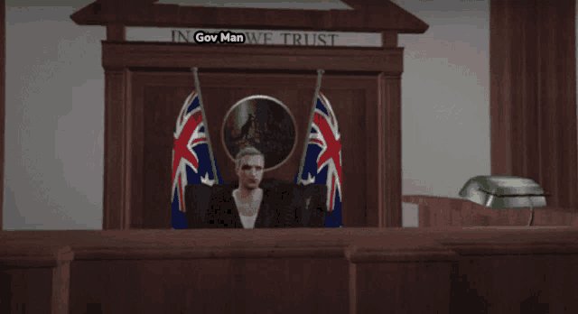 a man sitting in front of a sign that says gov man