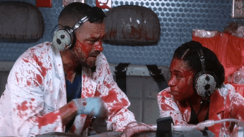 a man and a woman with blood on their faces are sitting next to each other