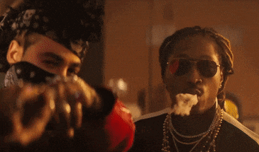 a man wearing sunglasses is smoking a pipe next to another man wearing a bandana