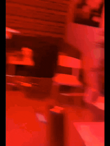 a blurry picture of a person standing in a room with red lights