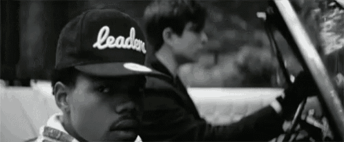 a black and white photo of a man wearing a hat that says leader