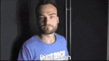 a man wearing a blue shirt that says rise clan