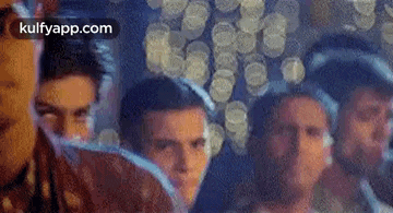 a group of men are standing next to each other in a room with coins in the background .