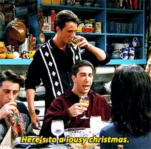 a group of people are sitting around a table with the words here 's to a lousy christmas