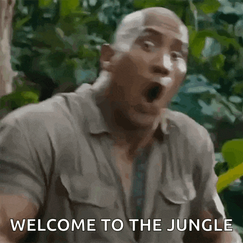 a man is standing in the jungle with his mouth open and the words welcome to the jungle written on his face .
