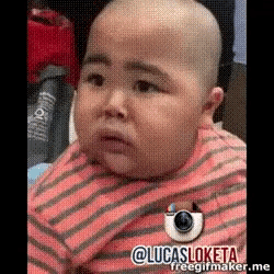 a baby with a bald head is wearing a pink striped shirt and making a funny face .