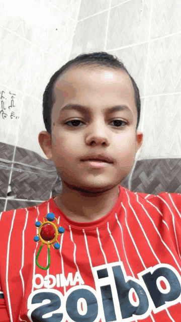 a boy wearing a red shirt that says adibp on it