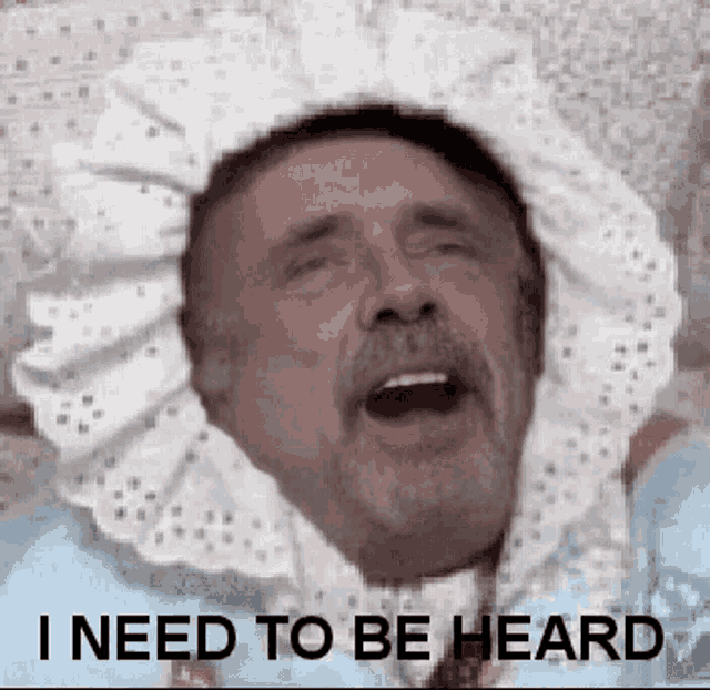 a man with a beard is wearing a baby 's diaper and says `` i need to be heard '' .