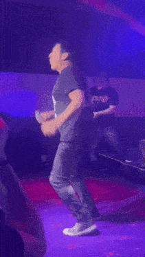 a man on stage wearing a shirt that says ' jesus loves you '