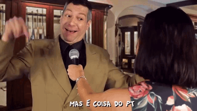 a man in a suit is being interviewed by a woman with the words mas e coisa do pt above him