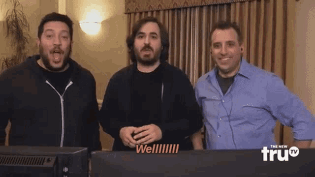 three men are standing in front of a screen that says " well " on it