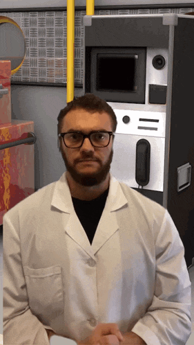 a man in a lab coat stands in front of a machine