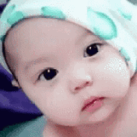 a close up of a baby wearing a hat .