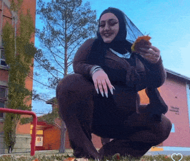 a woman squatting down in front of a building that says ' texas ' on it