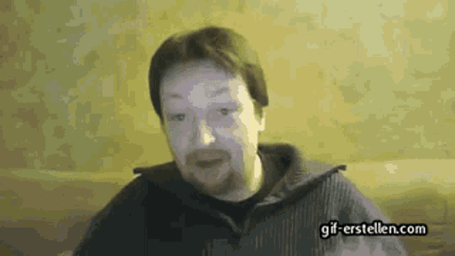 a man with a beard is looking at the camera with the website gif-erstellen.com visible in the corner
