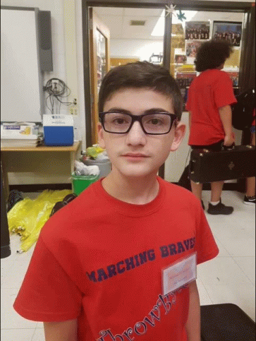 a young boy wearing glasses and a red marching brave shirt